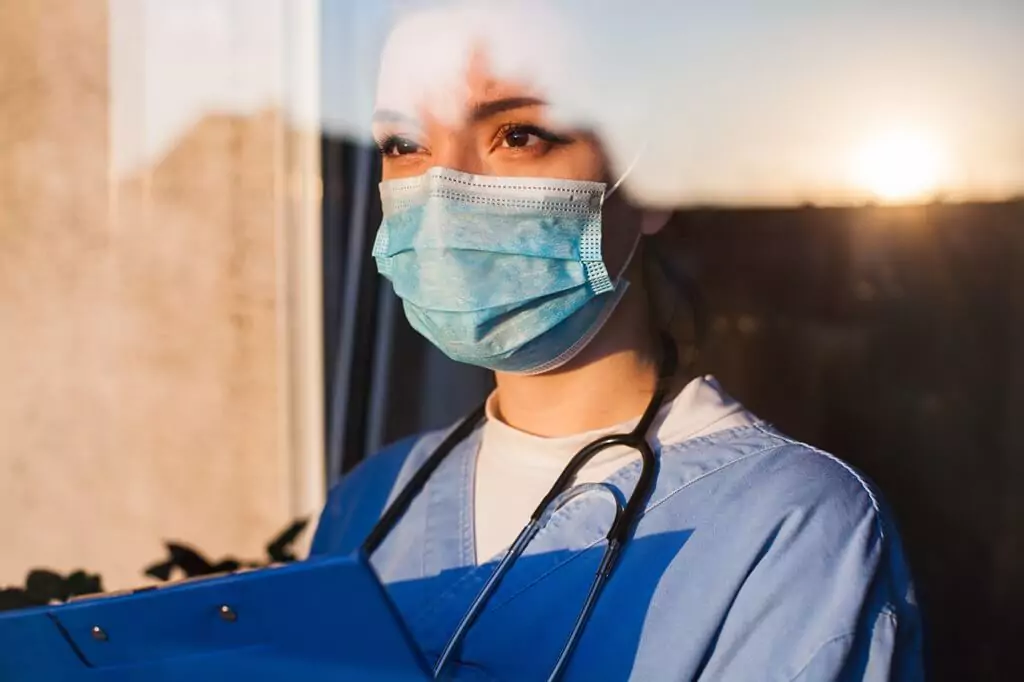 médica olhando pela janela